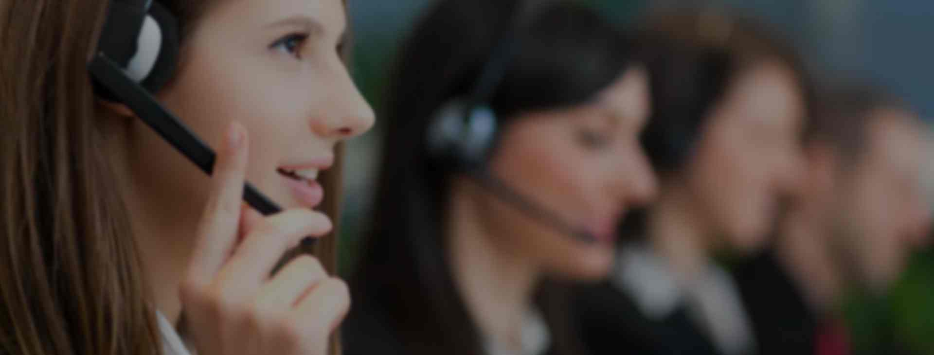 photo of 4 people in call center with woman in left foreground and three others blurred background