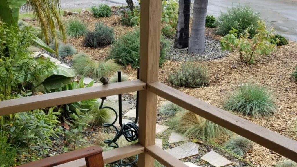 view from front porch of mature drought tolerant landscaping pavers mulch and river rock